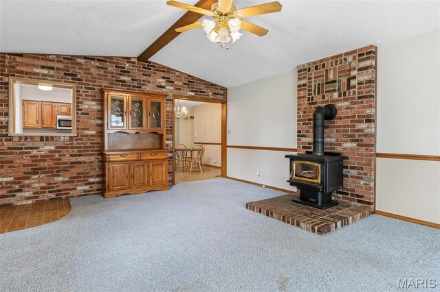 423 Rice Rd, Bonne Terre, MO 63628 - unfurnished living room featuring a wood stove, a ceiling fan, carpet flooring, baseboards, and brick wall