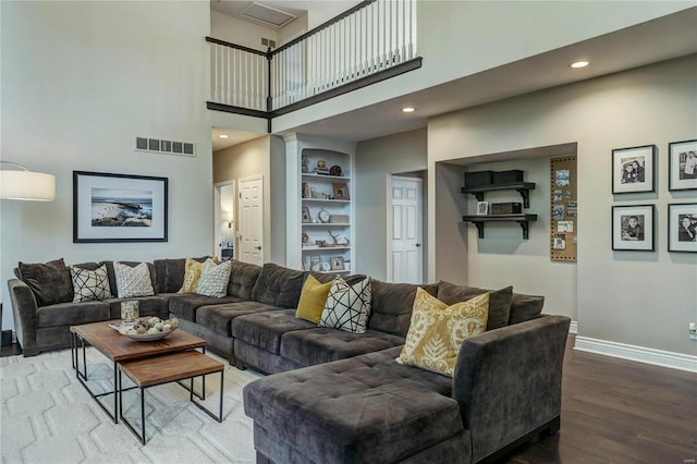 1155 Whitmoor Dr, Weldon Spring, MO 63304 - living room featuring baseboards, wood finished floors, a high ceiling, recessed lighting, and built in shelves