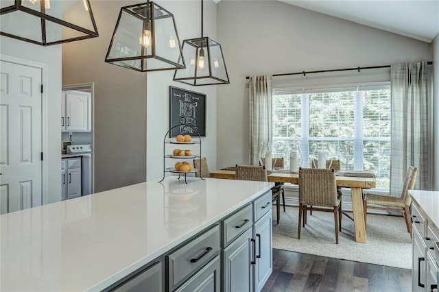 1155 Whitmoor Dr, Weldon Spring, MO 63304 - kitchen with dark wood-style floors, light countertops, high vaulted ceiling, pendant lighting, and white cabinetry