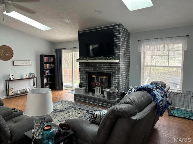 70 Innsbruck Ln, Shiloh, IL 62221 - living area with a skylight, wood finished floors, vaulted ceiling, a ceiling fan, and a fireplace