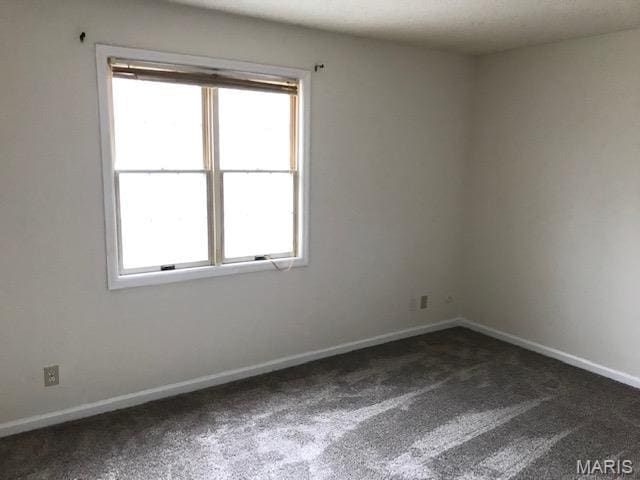 1723 Canary Cv, Brentwood, MO 63144 - unfurnished room with dark colored carpet, plenty of natural light, and baseboards