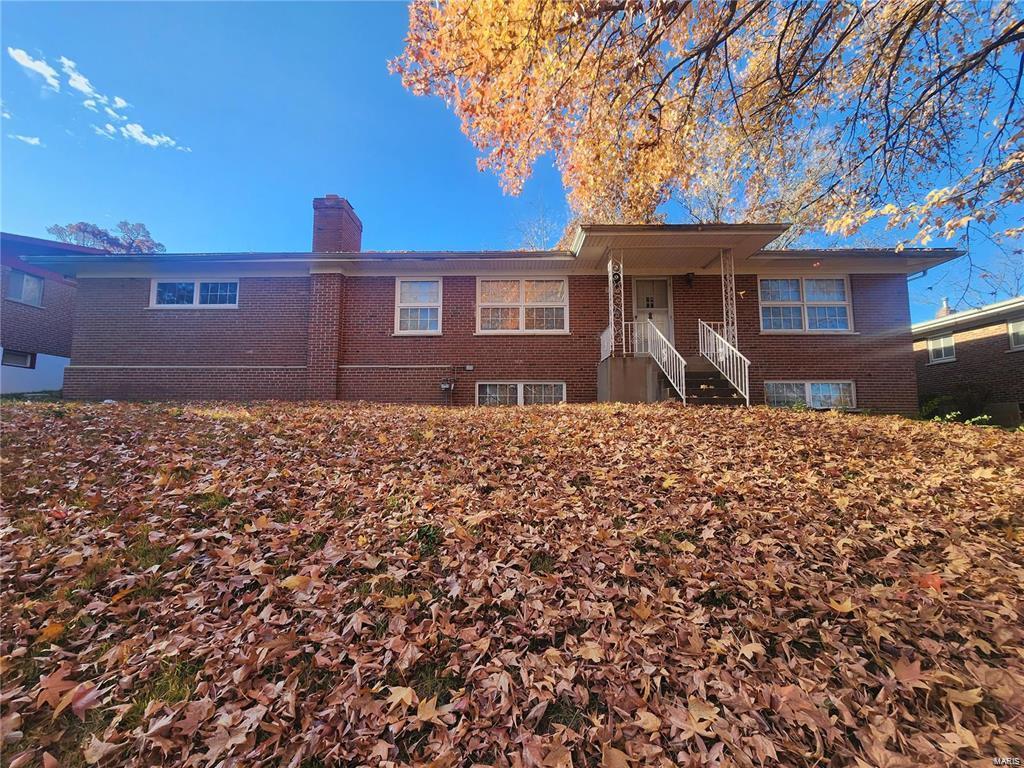 7712 Nacomis Dr, Saint Louis, MO 63121 - view of front of home with brick siding and a chimney
