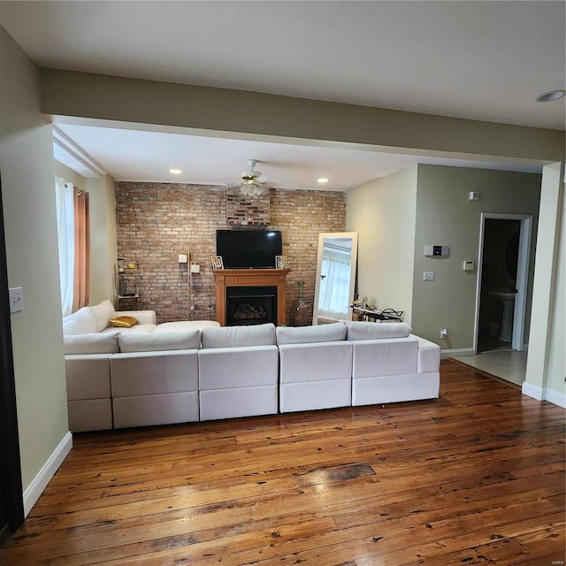 2438 Lemp Ave, Saint Louis, MO 63104 - living room with hardwood / wood-style floors, baseboards, a brick fireplace, brick wall, and recessed lighting