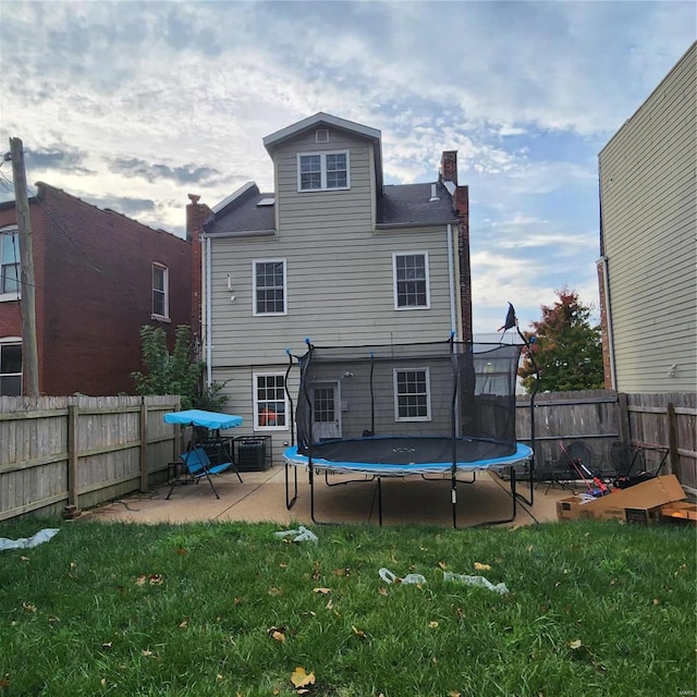 2438 Lemp Ave, Saint Louis, MO 63104 - rear view of property featuring a trampoline, a patio, a chimney, and cooling unit