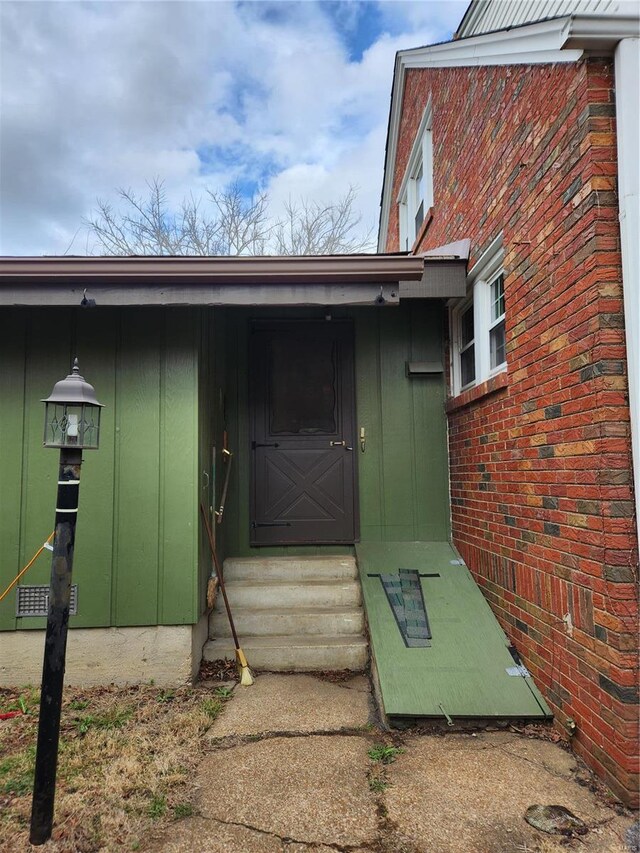 entrance to property with brick siding and board and batten siding