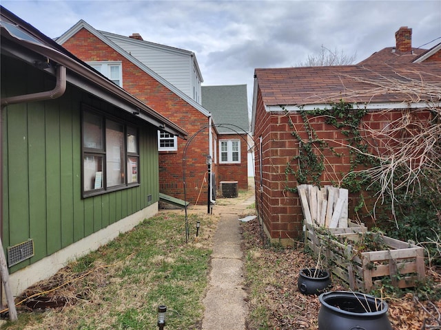 view of property exterior with cooling unit and brick siding