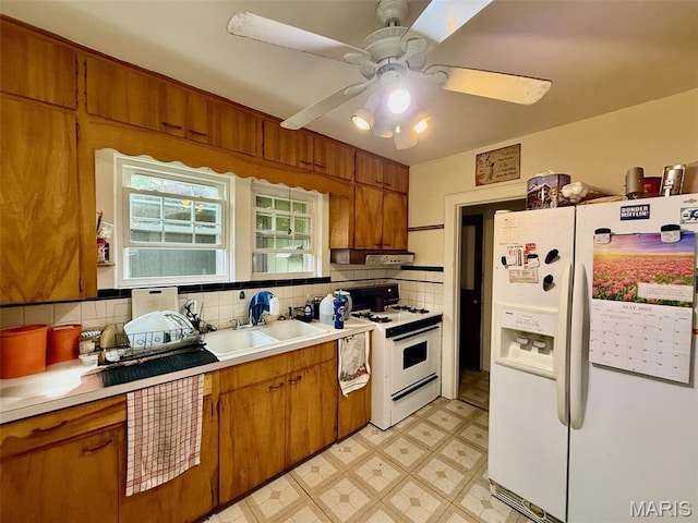 210 Linn St, Belle, MO 65013 - kitchen with white appliances, brown cabinets, under cabinet range hood, decorative backsplash, and light countertops