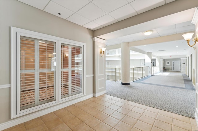 spare room featuring light tile patterned floors, light carpet, a chandelier, and baseboards