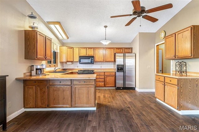 207 Normandie Dr, Bonne Terre, MO 63628 - kitchen with appliances with stainless steel finishes, a peninsula, light countertops, dark wood finished floors, and a textured ceiling