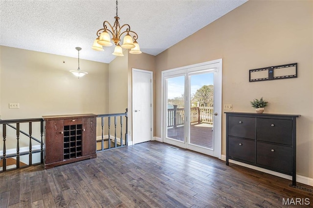 207 Normandie Dr, Bonne Terre, MO 63628 - spare room with vaulted ceiling, a chandelier, wood finished floors, and a textured ceiling