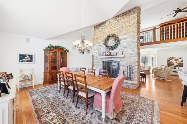 900 Deer Circle Dr, Carlyle, IL 62231 - dining area with high vaulted ceiling, light wood-type flooring, a fireplace, a chandelier, and a ceiling fan