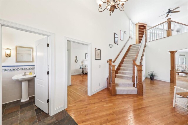 900 Deer Circle Dr, Carlyle, IL 62231 - staircase with a high ceiling, a chandelier, ceiling fan, wood finished floors, and tile walls