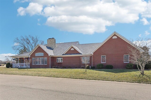 900 Deer Circle Dr, Carlyle, IL 62231 - view of front facade with brick siding, a front yard, and a chimney