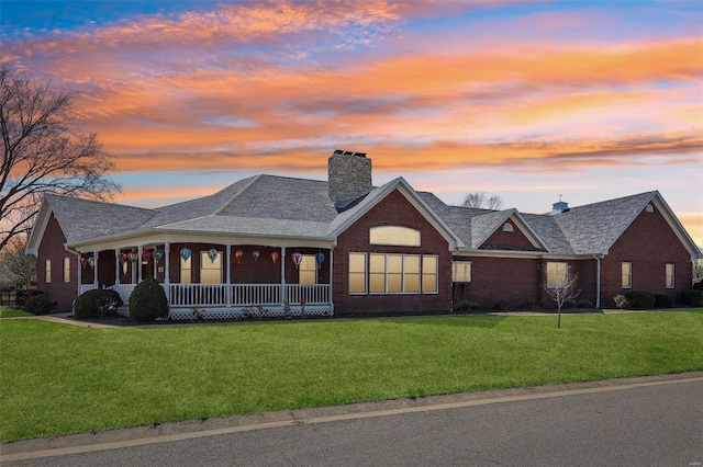 900 Deer Circle Dr, Carlyle, IL 62231 - view of front facade with a lawn, brick siding, covered porch, and a chimney