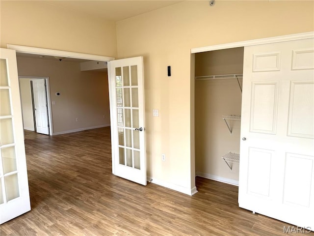 2 Monarch Trace Ct Unit 103, Chesterfield, MO 63017 - unfurnished bedroom with a closet, french doors, baseboards, and wood finished floors