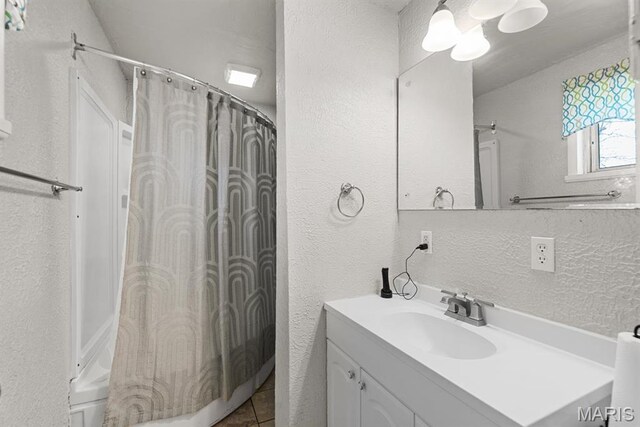2755 Patterson Rd, Florissant, MO 63031 - bathroom featuring a textured wall, vanity, shower / tub combo, and tile patterned flooring