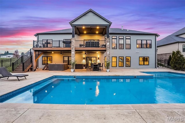 1520 Oglesby Dr, Edwardsville, IL 62025 - back of house at dusk with a balcony, a ceiling fan, stairs, fence, and a patio