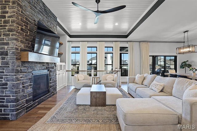 1520 Oglesby Dr, Edwardsville, IL 62025 - living room featuring wood finished floors, ceiling fan, a stone fireplace, and healthy amount of natural light