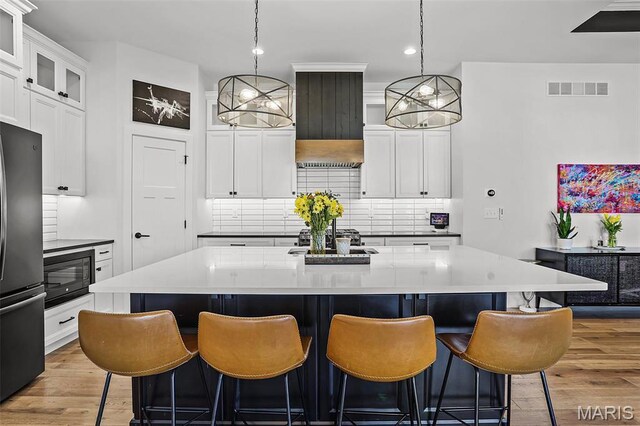 1520 Oglesby Dr, Edwardsville, IL 62025 - kitchen featuring freestanding refrigerator, black microwave, tasteful backsplash, wood finished floors, and recessed lighting