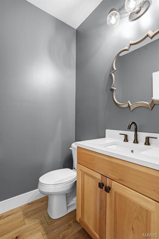1520 Oglesby Dr, Edwardsville, IL 62025 - half bath featuring toilet, vanity, wood finished floors, and baseboards
