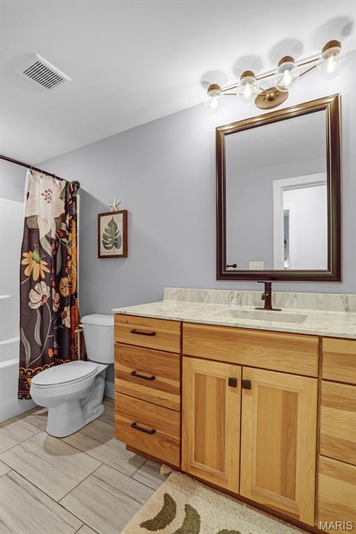 1520 Oglesby Dr, Edwardsville, IL 62025 - bathroom featuring toilet, vanity, a chandelier, and shower / tub combo with curtain