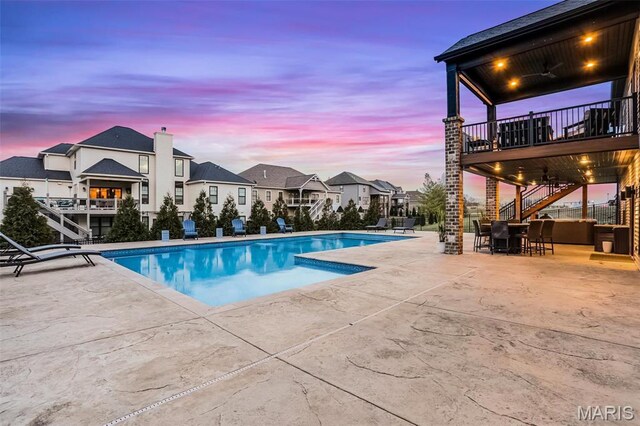 1520 Oglesby Dr, Edwardsville, IL 62025 - pool at dusk with stairs, a patio area, an outdoor pool, and a residential view