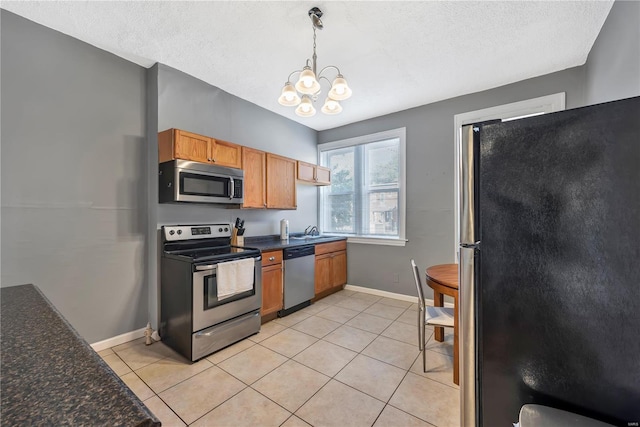 2107 Russell Blvd, Saint Louis, MO 63104 - kitchen featuring stainless steel appliances, a sink, a chandelier, baseboards, and a textured ceiling