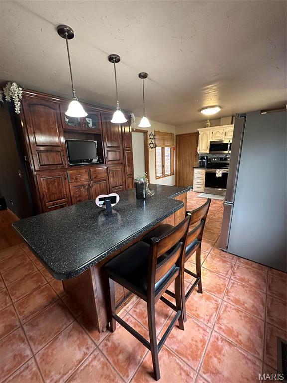 417 Carriage Pl, Lebanon, MO 65536 - kitchen with stainless steel appliances, light tile patterned flooring, and decorative light fixtures