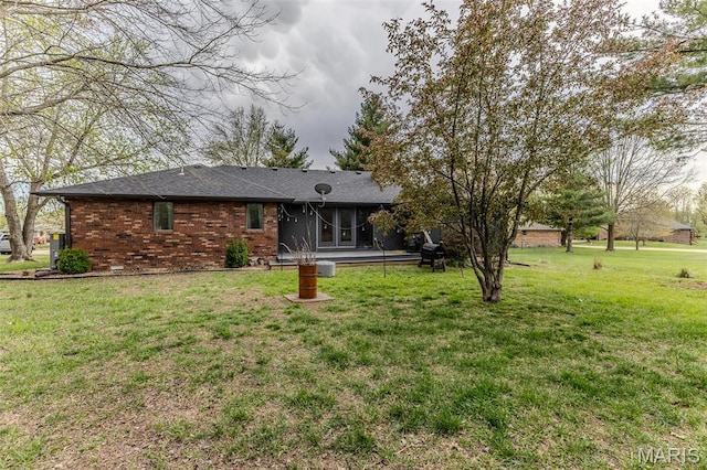 417 Carriage Pl, Lebanon, MO 65536 - back of house featuring a yard, brick siding, and a sunroom