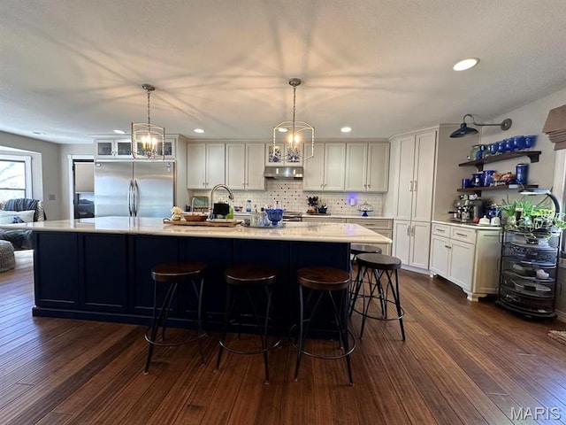 14348 Hidden Trails Cir, Dexter, MO 63841 - kitchen with stainless steel fridge, open shelves, light countertops, white cabinetry, and dark wood finished floors