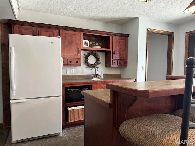 14348 Hidden Trails Cir, Dexter, MO 63841 - kitchen featuring freestanding refrigerator, a sink, a kitchen bar, open shelves, and dark countertops