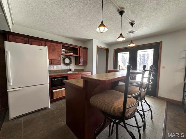 14348 Hidden Trails Cir, Dexter, MO 63841 - kitchen featuring freestanding refrigerator, dark tile patterned floors, black microwave, a sink, and dark countertops