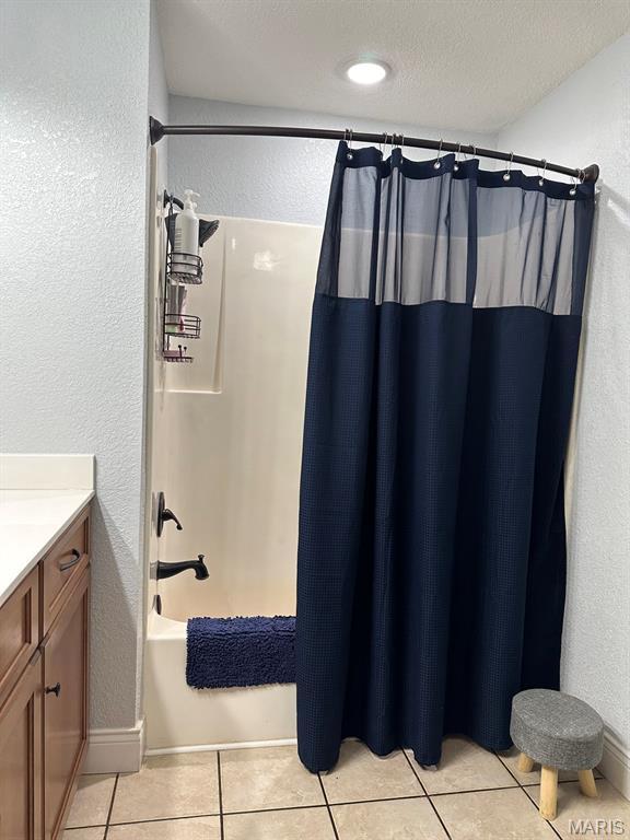 14348 Hidden Trails Cir, Dexter, MO 63841 - full bathroom featuring vanity, a textured wall, tile patterned floors, and shower / tub combo