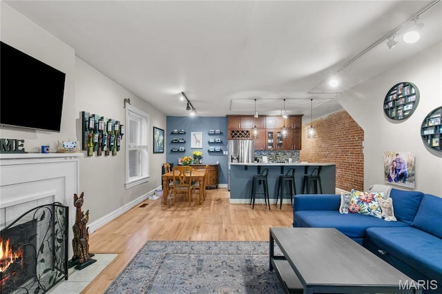 4486 Laclede Ave Unit 4486, Saint Louis, MO 63108 - living area with track lighting, light wood-type flooring, a fireplace with flush hearth, and baseboards