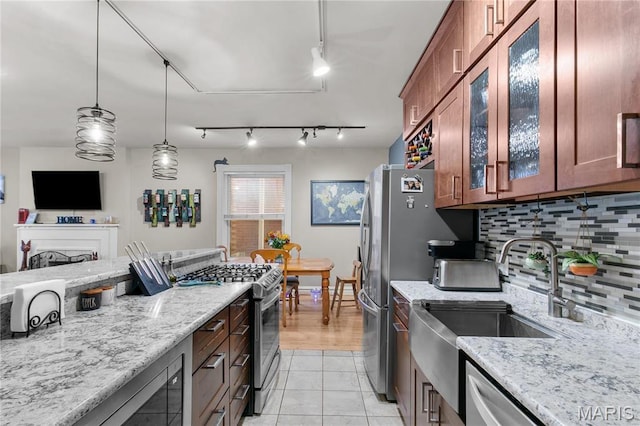 4486 Laclede Ave Unit 4486, Saint Louis, MO 63108 - kitchen with stainless steel appliances, light stone counters, backsplash, glass insert cabinets, and light tile patterned flooring