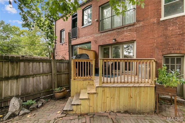 4486 Laclede Ave Unit 4486, Saint Louis, MO 63108 - back of house featuring brick siding, a fenced backyard, and a wooden deck