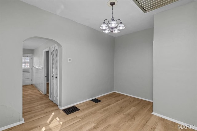 5331 Arsenal St, Saint Louis, MO 63139 - unfurnished room with arched walkways, light wood-style flooring, a chandelier, and baseboards