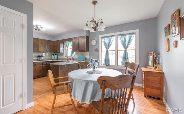 400 S Hickory St, Salem, MO 65560 - dining area with a chandelier, light wood-style floors, and baseboards