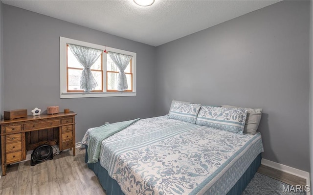 400 S Hickory St, Salem, MO 65560 - bedroom featuring wood finished floors, a textured ceiling, and baseboards