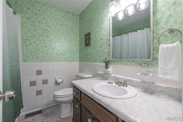 400 S Hickory St, Salem, MO 65560 - full bath featuring wallpapered walls, toilet, vanity, a wainscoted wall, and tile walls