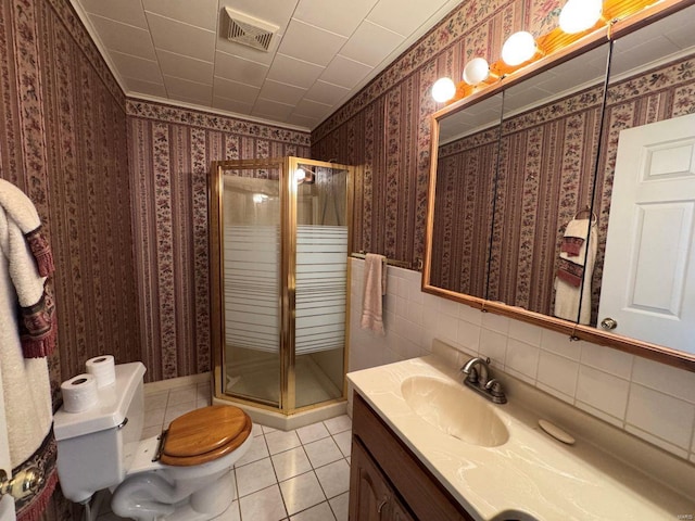 bathroom featuring a stall shower, tile patterned floors, toilet, vanity, and wallpapered walls