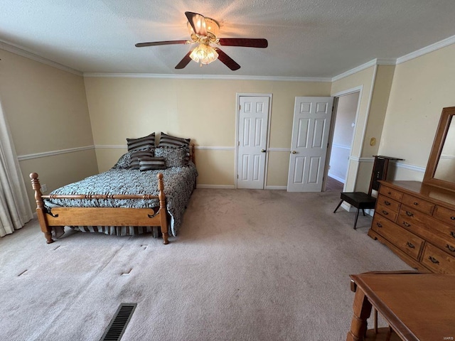 carpeted bedroom featuring ornamental molding, ceiling fan, a textured ceiling, and baseboards