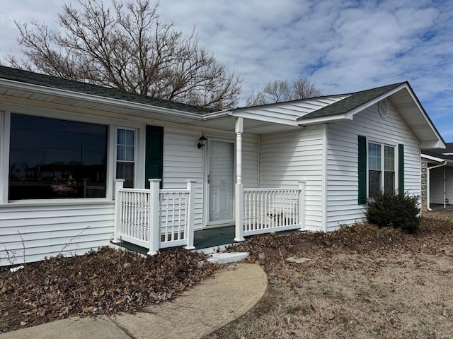 view of front of property with a porch and roof with shingles
