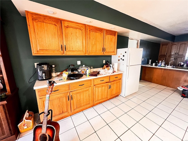 1505 Shelley Dr, Vandalia, IL 62471 - kitchen with freestanding refrigerator, light countertops, brown cabinets, and light tile patterned flooring