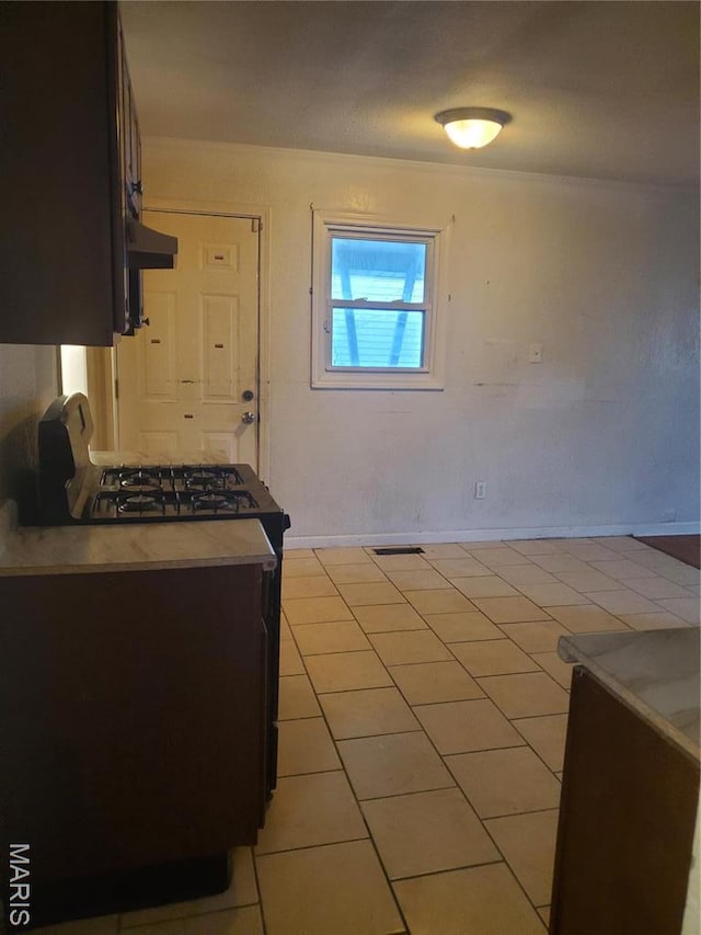 20 Leonard Dr, Cahokia, IL 62206 - kitchen with under cabinet range hood, light tile patterned floors, and tile counters