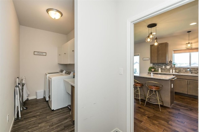 237 Mason Glen Dr, Lake St Louis, MO 63367 - clothes washing area with washing machine and clothes dryer, dark wood finished floors, cabinet space, and baseboards