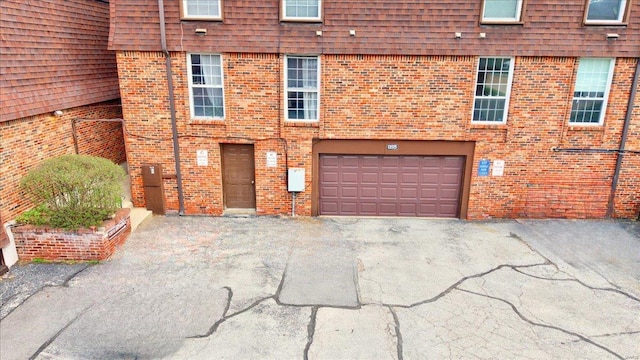 13515 Coliseum Dr Unit A, Chesterfield, MO 63017 - view of front of property featuring asphalt driveway, an attached garage, and brick siding