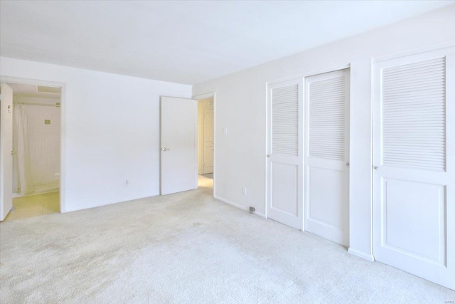 13515 Coliseum Dr Unit A, Chesterfield, MO 63017 - unfurnished bedroom featuring light carpet, multiple closets, and connected bathroom
