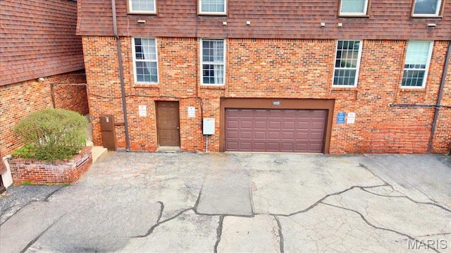 13515 Coliseum Dr Unit A, Chesterfield, MO 63017 - rear view of property with asphalt driveway, brick siding, and a garage