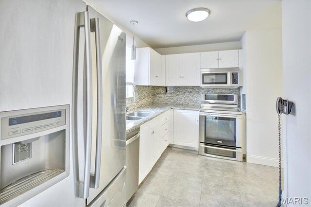 13515 Coliseum Dr Unit A, Chesterfield, MO 63017 - kitchen featuring appliances with stainless steel finishes, a sink, white cabinetry, tasteful backsplash, and light countertops